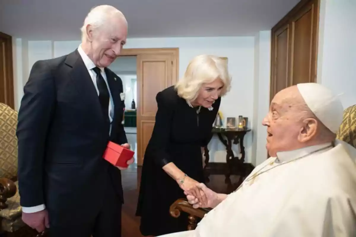 An elderly couple greeting an older man dressed in white in a room. An elderly couple greeting an older man dressed in white in a room.