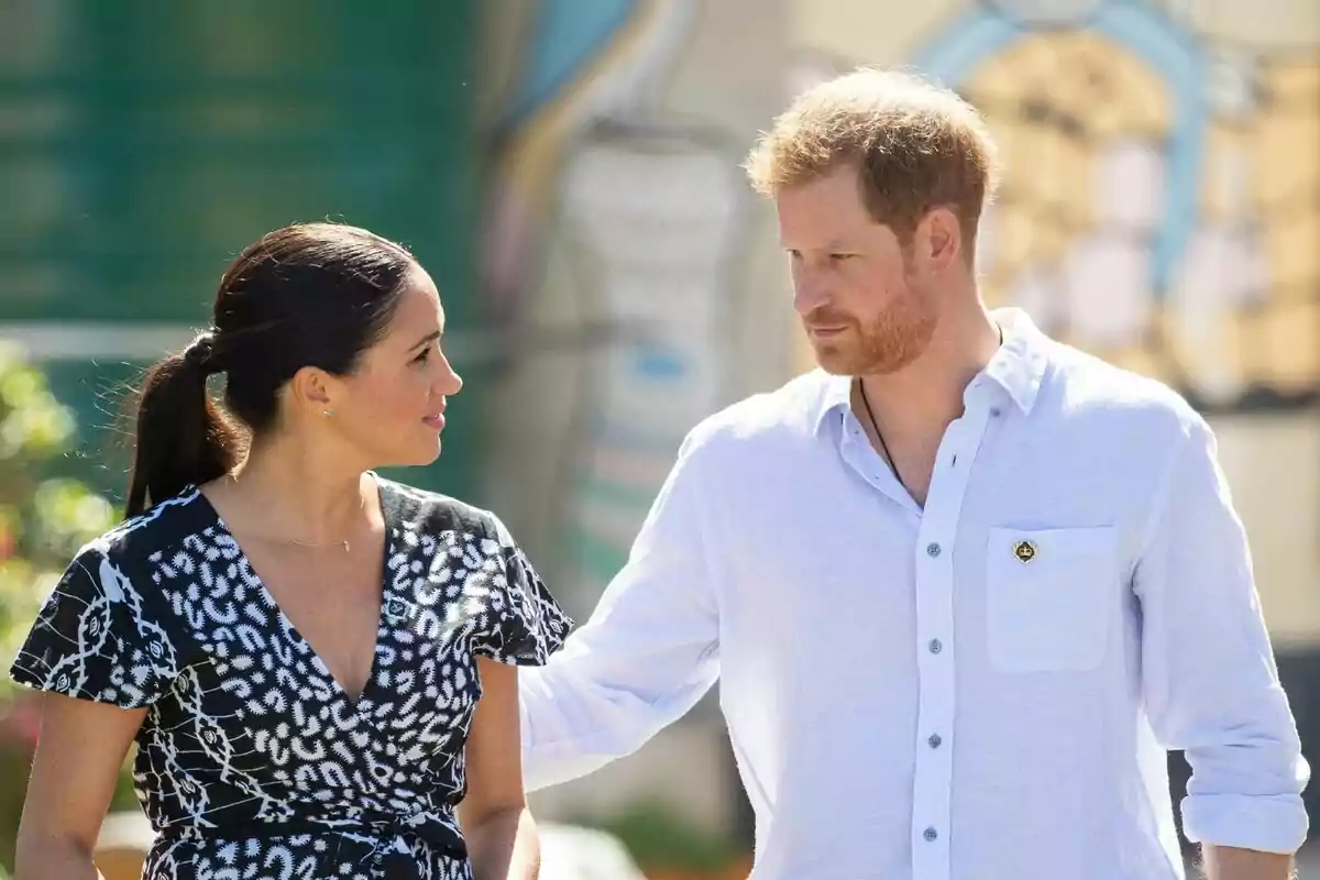A couple walking outdoors while looking at each other affectionately. A couple walking outdoors while looking at each other affectionately.
