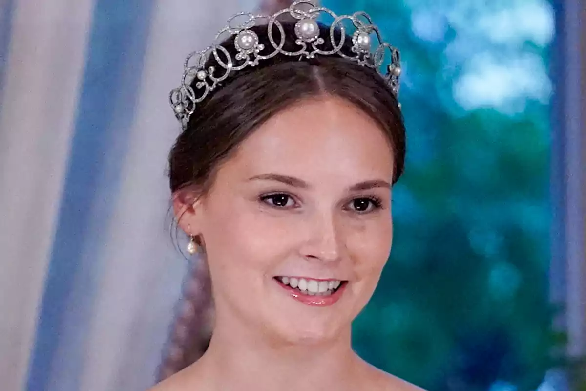 Princess Ingrid Alexandra, smiling, wears an elegant tiara with pearls and intricate details, set against a blurred background of blue and green tones. Princess Ingrid Alexandra, smiling, wears an elegant tiara with pearls and intricate details, set against a blurred background of blue and green tones.